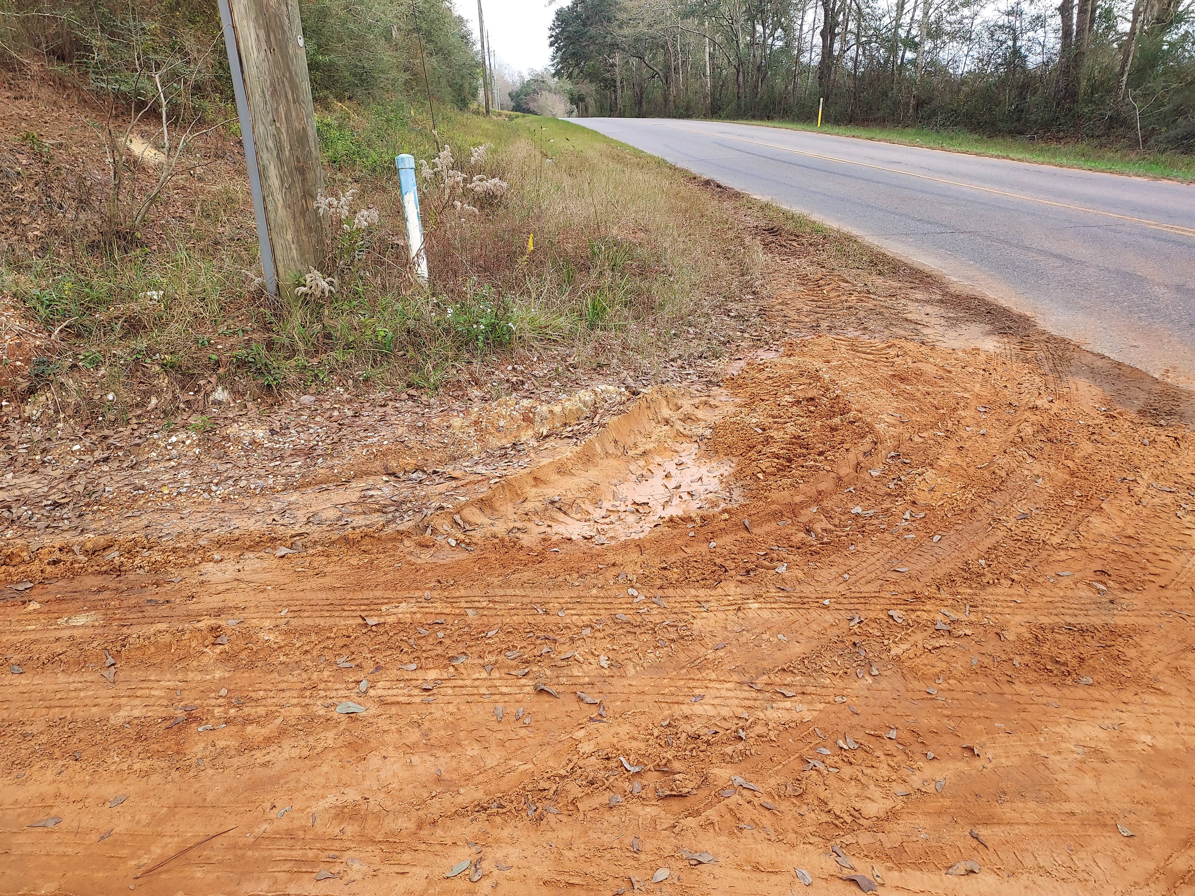 photo of red clay road intersecting with paved road