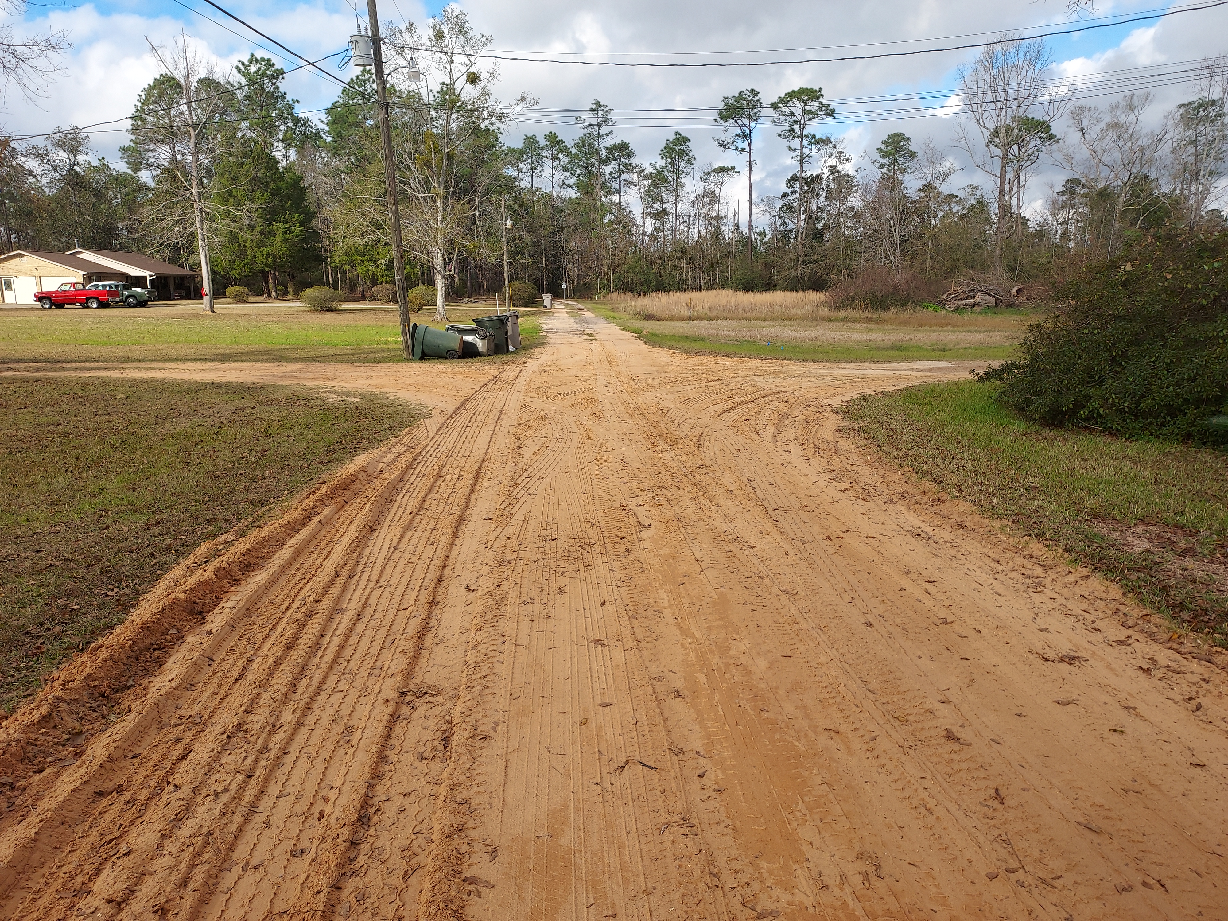 phot of red clay road before paving