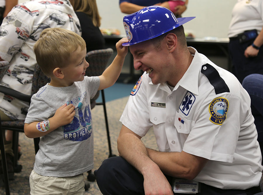 An EMS staff member's child puts a hat on his head