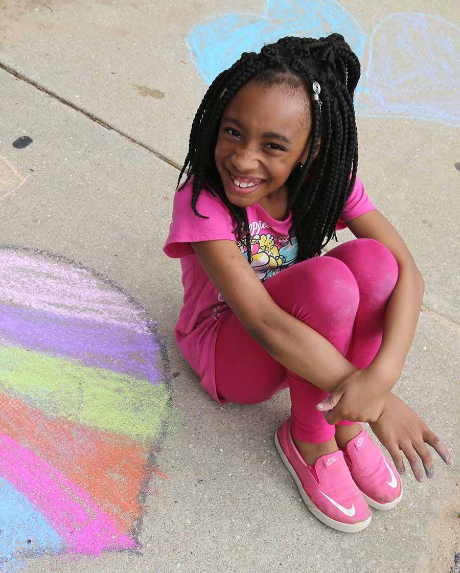 A young girl shows off her chalk art at the Brownsville Community Center