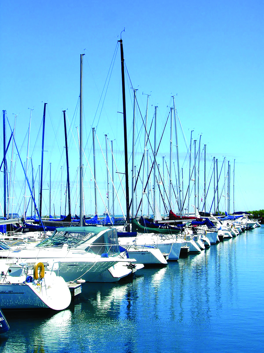 Boats sit in a harbor on a sunny day.