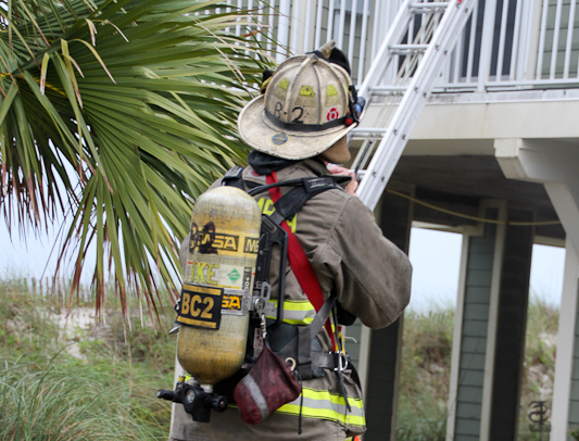 A firefighter works outside of a home in Escambia County.