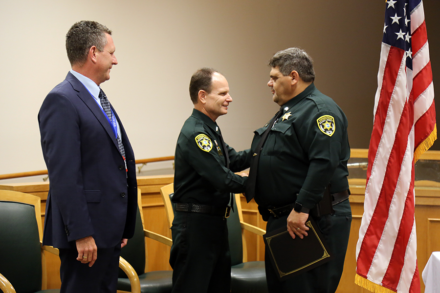 Assistant County Administrator Matt Coughlin and 1st Lt. Jason Walker congratulate award recipients at the Aug. 22 Corrections Staff Award Ceremony