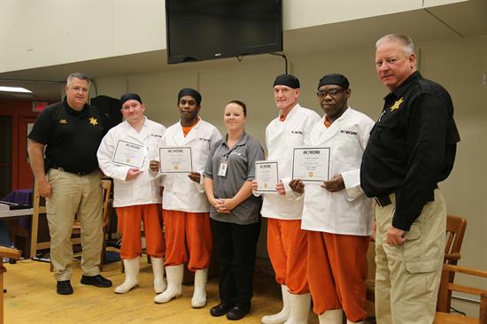 Chief of Corrections William Powell, Logan Nall, Demontra Jackson, Food Services Director Leslie Hall, Edward Nelson, Christopher Atkins and Commander Greg Nash at the IN2WORK graduation ceremony Tuesday, Aug. 6 at the Escambia County Jail. 