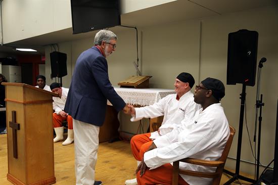Chaplain William Leggett speaks with recent IN2WORK graduates at a ceremony Tuesday, Aug. 6 at the Escambia County Jail. 