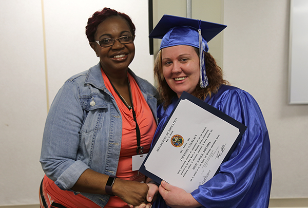 Instructor Rayshell Fairley recognizes Courtney Dunlavy with her diploma at a GED graduation ceremony at the Escambia County Jail.