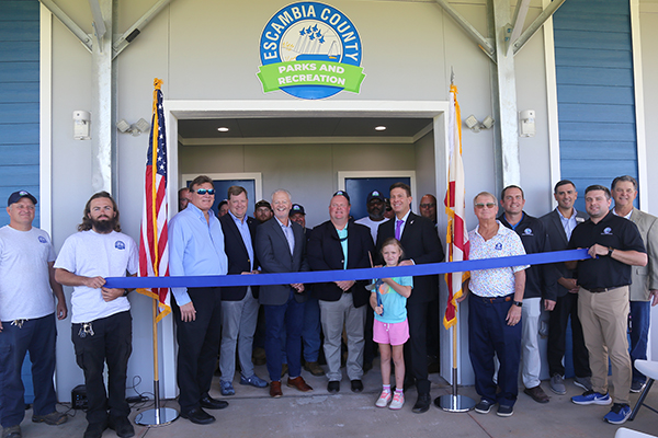 District 5 Commissioner Steven Barry and others celebrate the ribbon cutting of a new facility at Ashton Brosnaham Athletic Park.