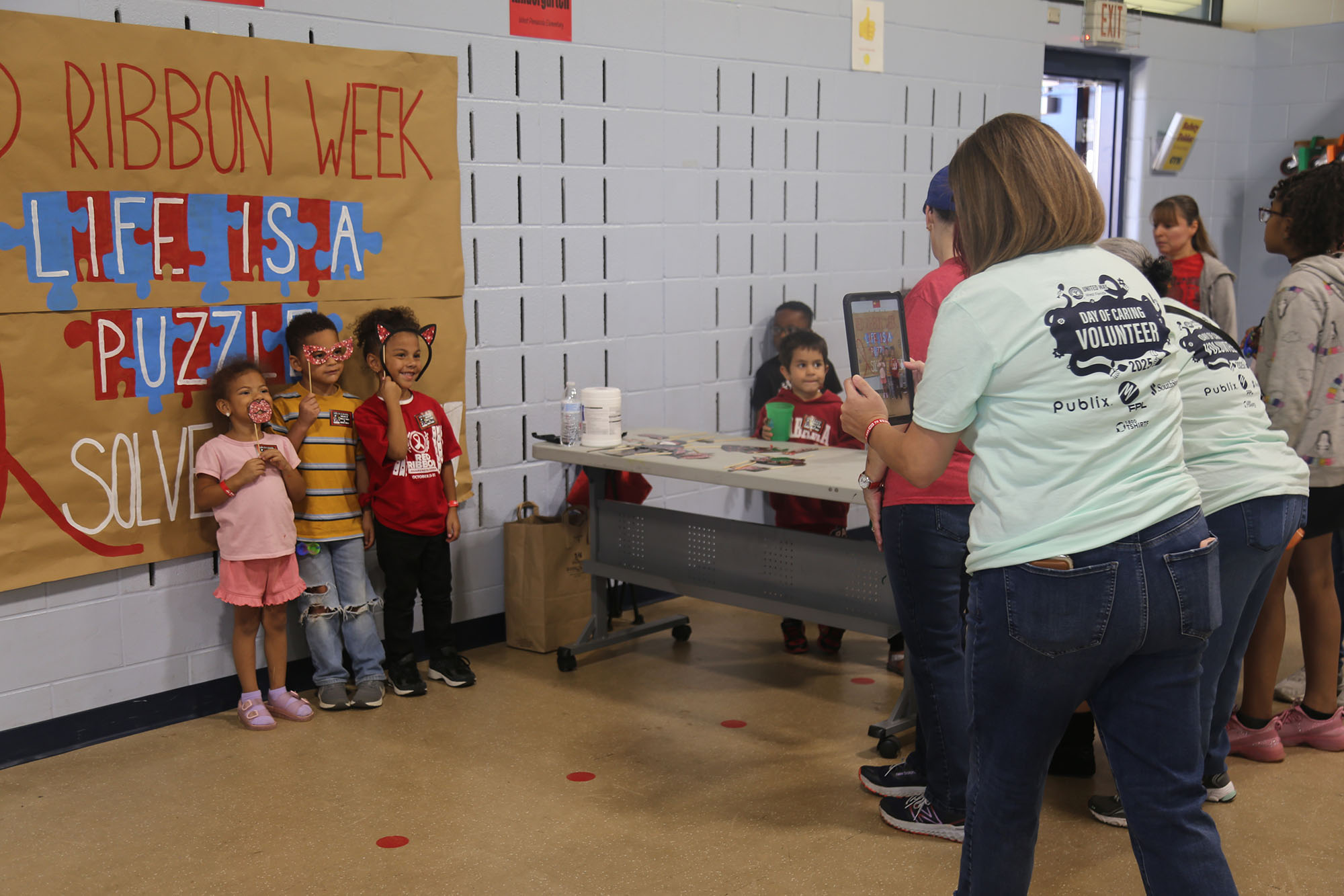 BCC Community Crusaders at Day of Caring Woman taking a photo of children