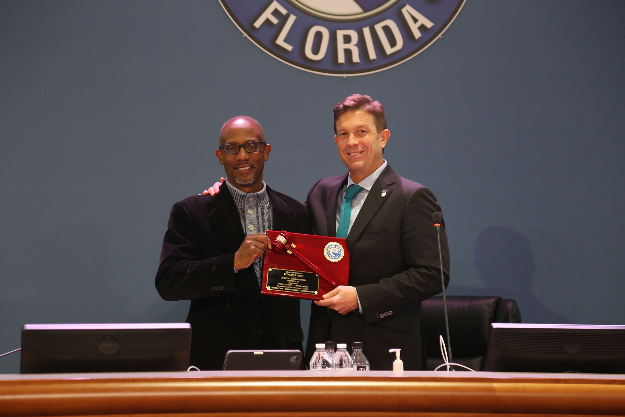 Commissioner May accepts a plaque from Commissioner Barry for his time as chairman during the previous year.