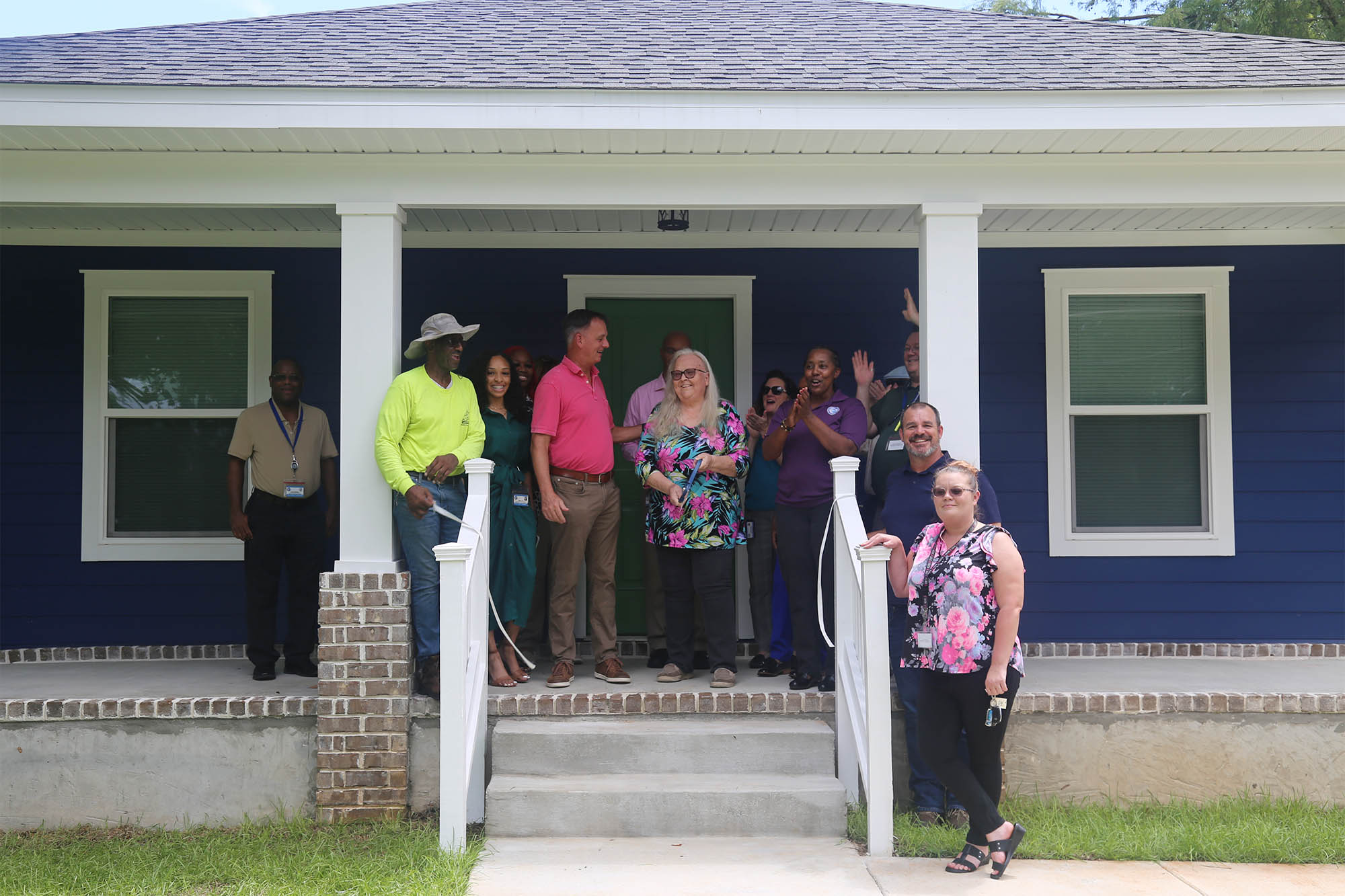 Emma Coker cuts the ribbon on her new home with county staff