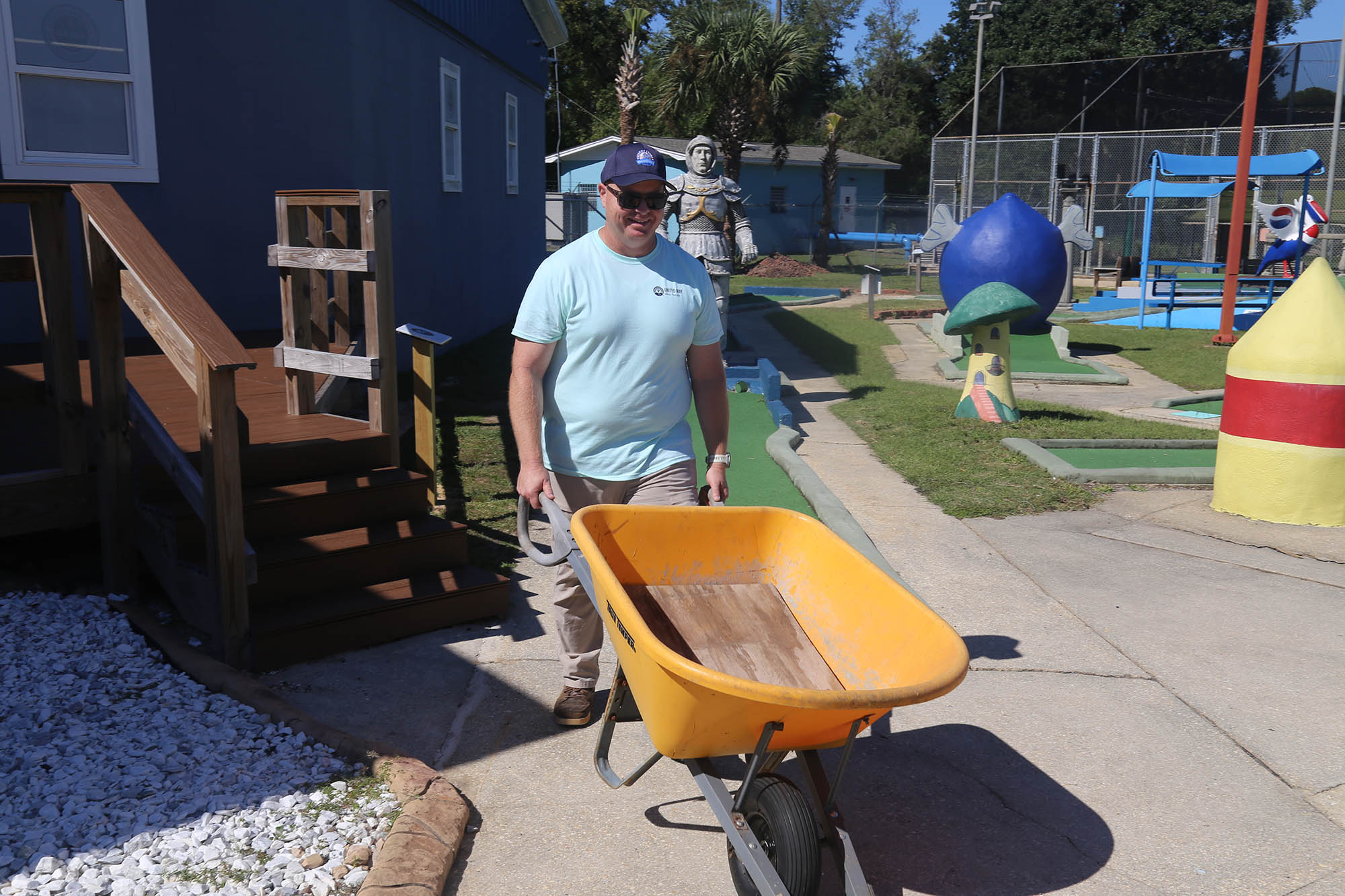 Engineering at Day of Caring Man carrying wheelbarrow