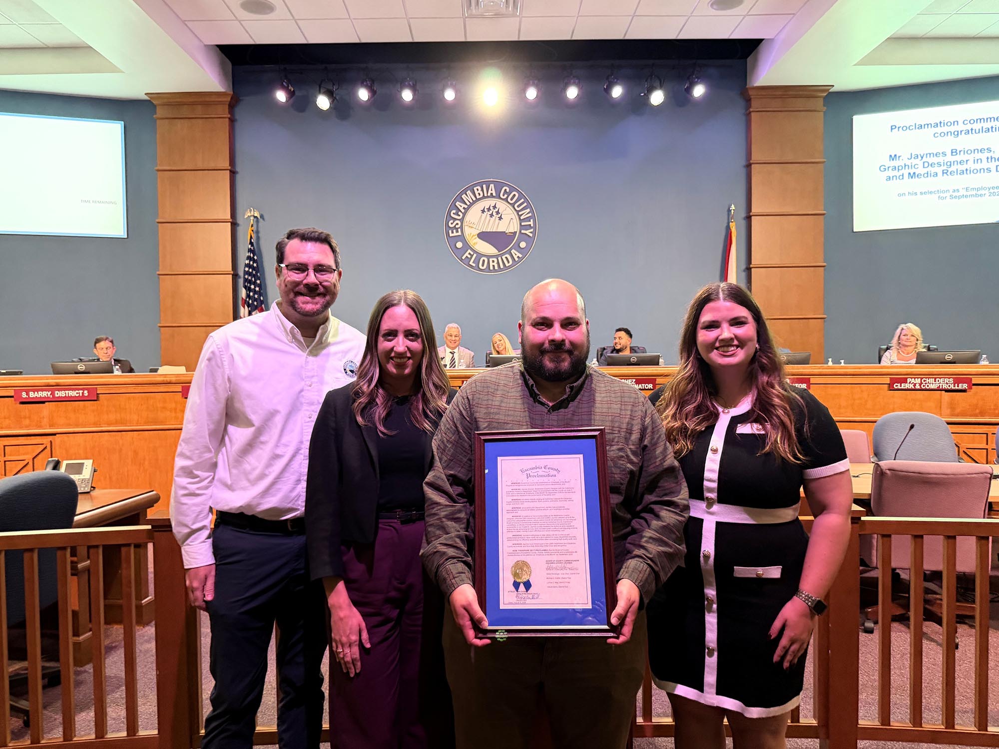 Man holding a proclamation with his team members