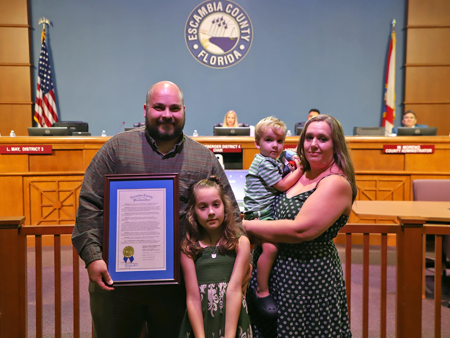 Man holding a proclamation standing with his family