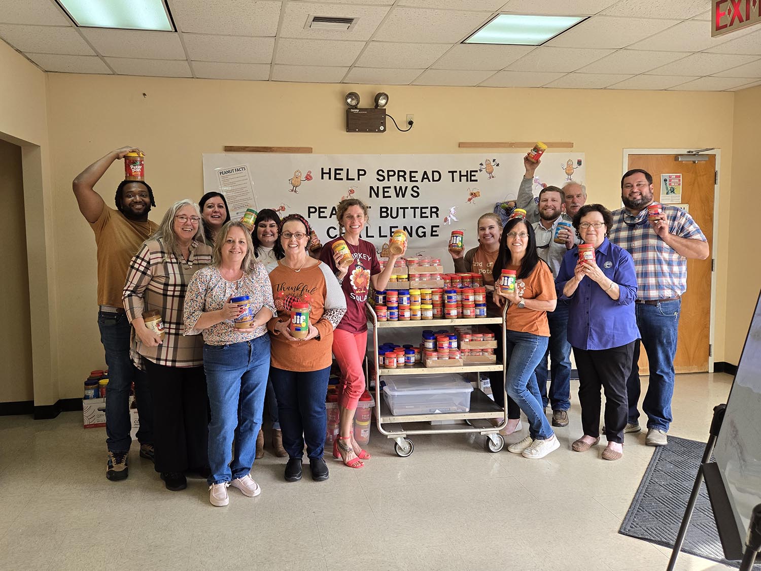 Group of people holding peanut butter jars