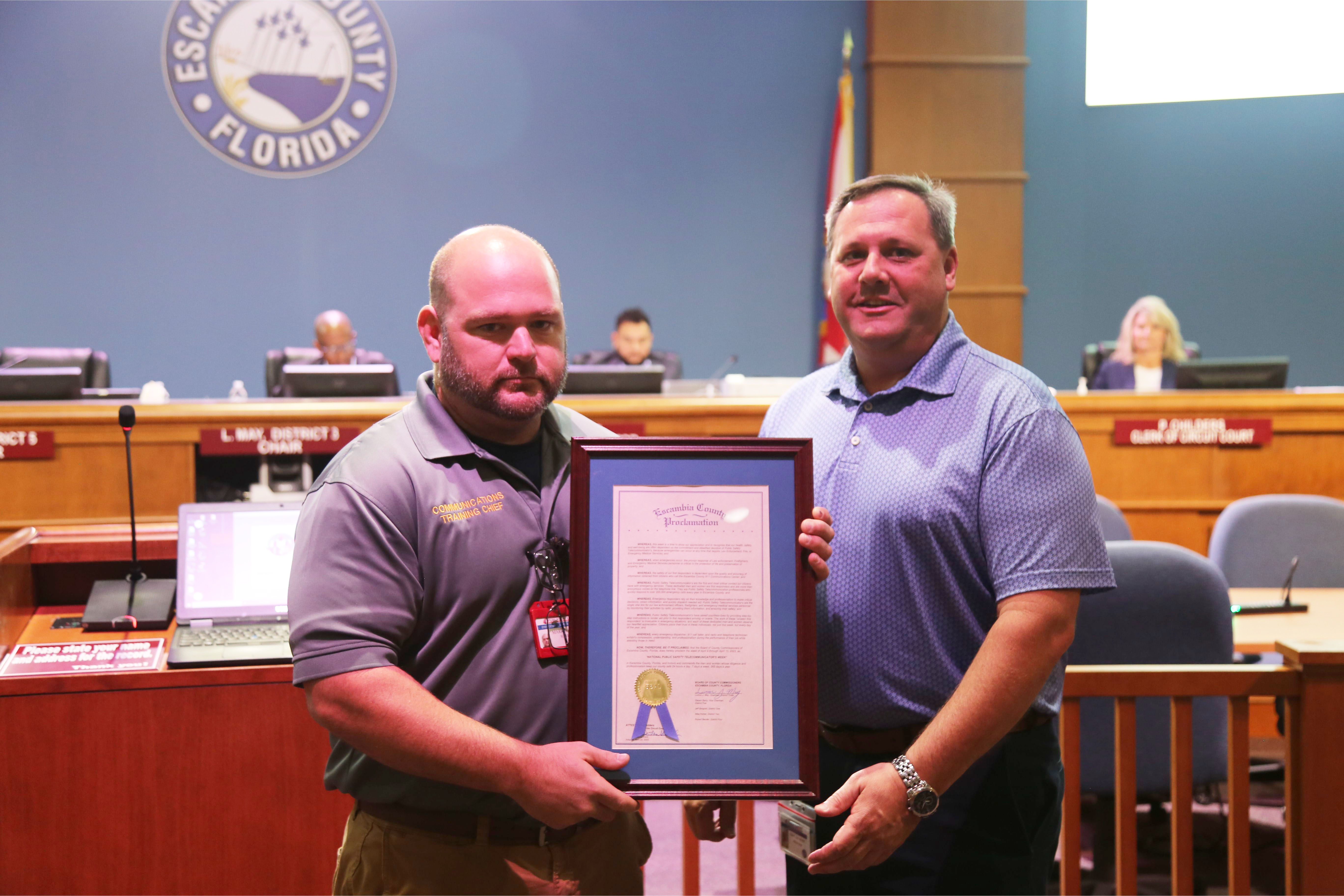 Eric Gilmore and Mark Carter posing with the Telecommunicators Week proclamation