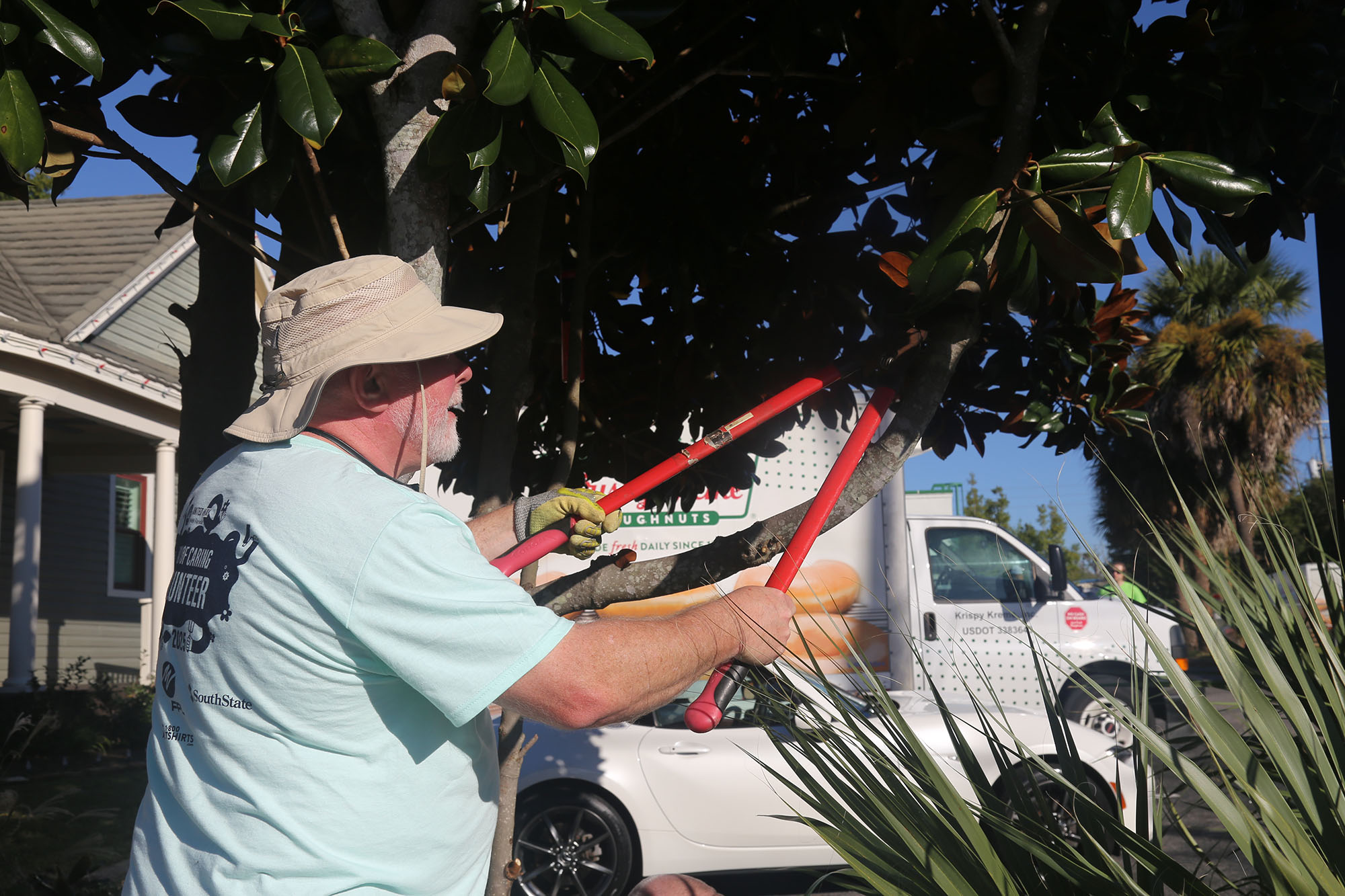 Waste Services at Day of Caring Man trimming a tree