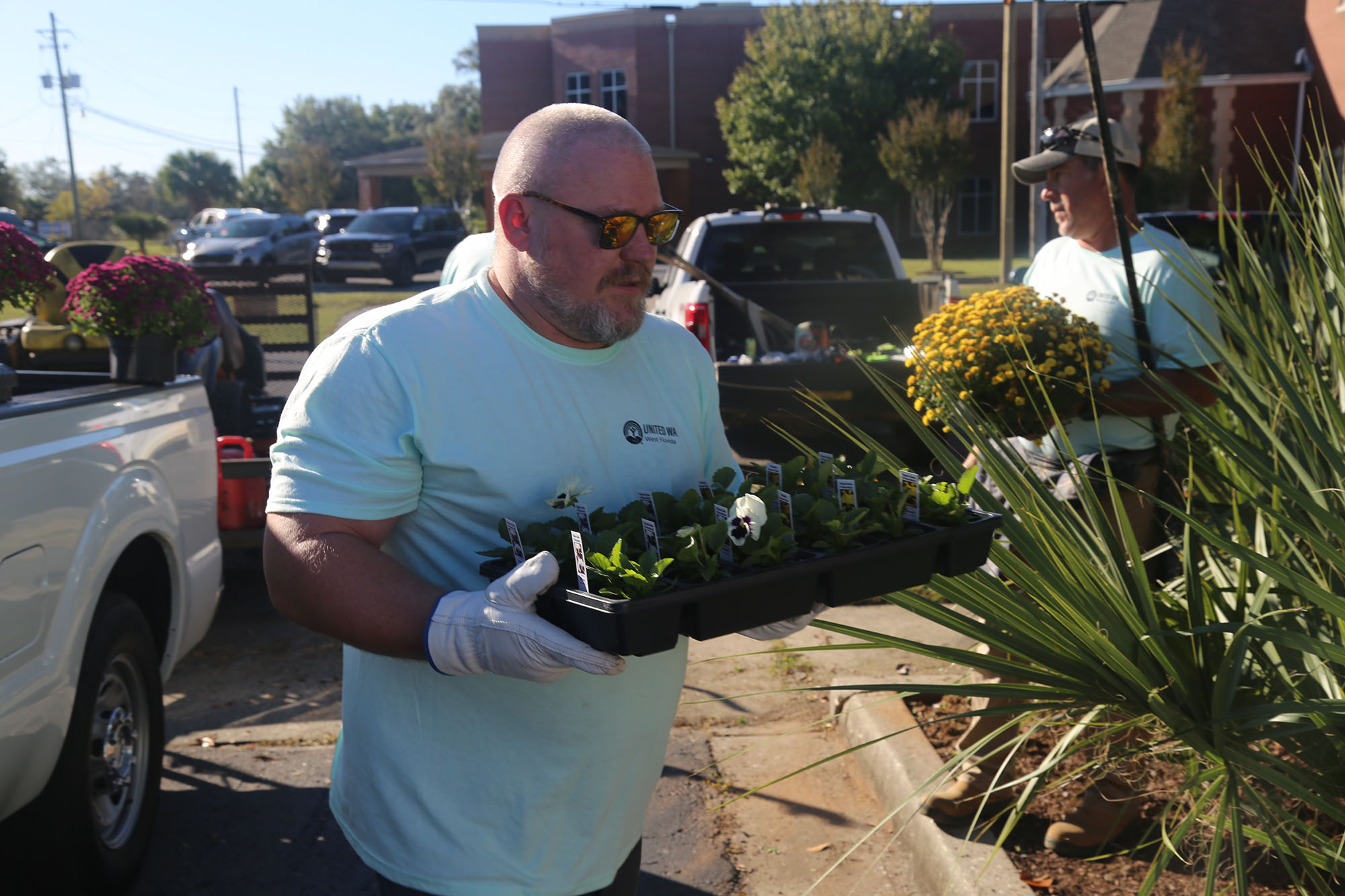 Waste Services at Day of Caring Man carrying potted plants