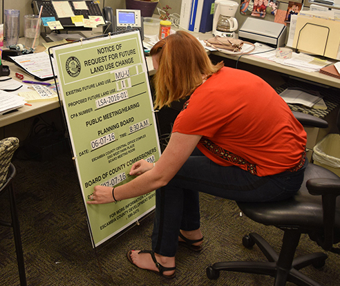 A Planning Board clerk readies a zoning case sign for placement