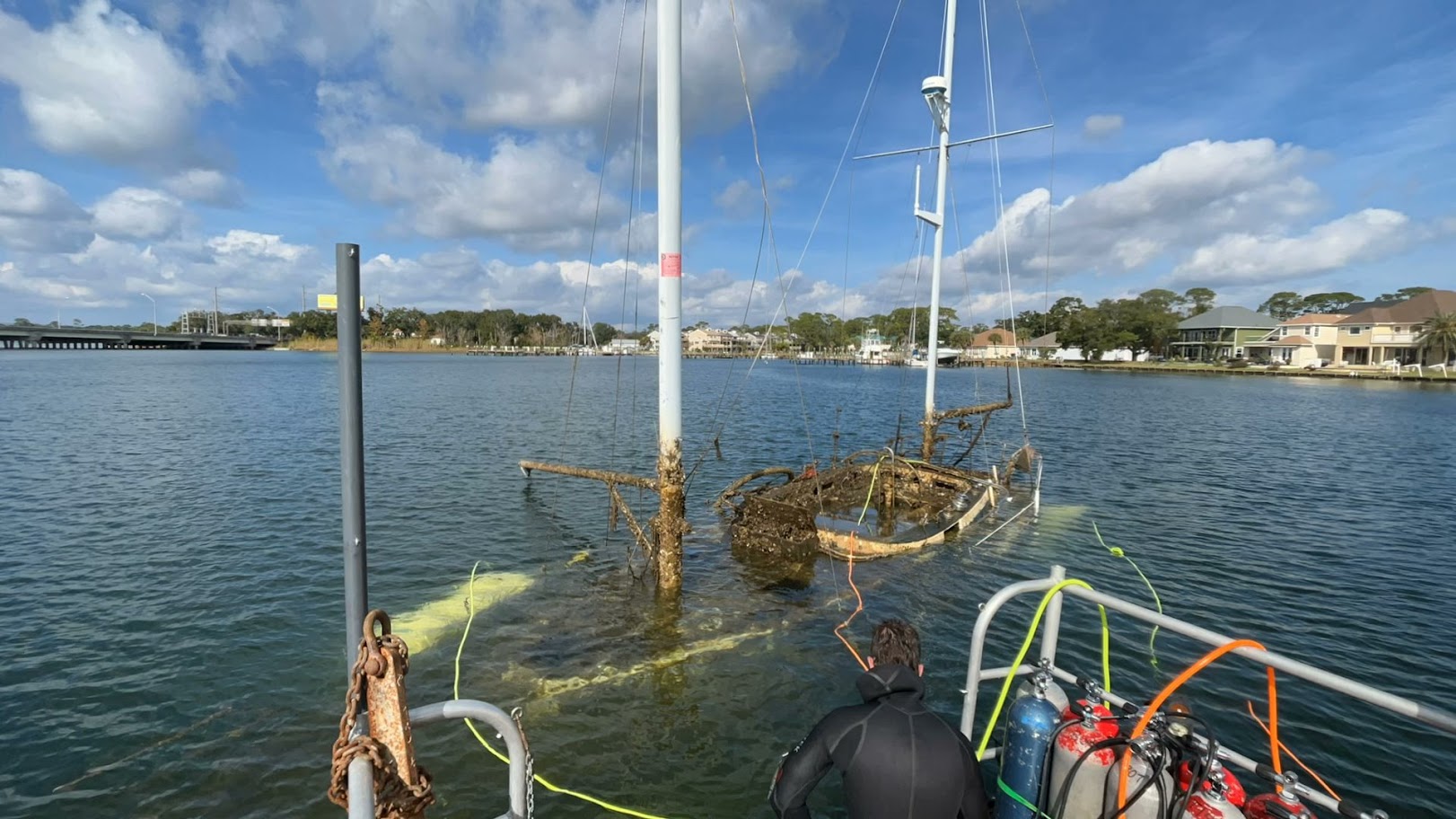Salvage team raising a derelict sailboat in Bayou Grande