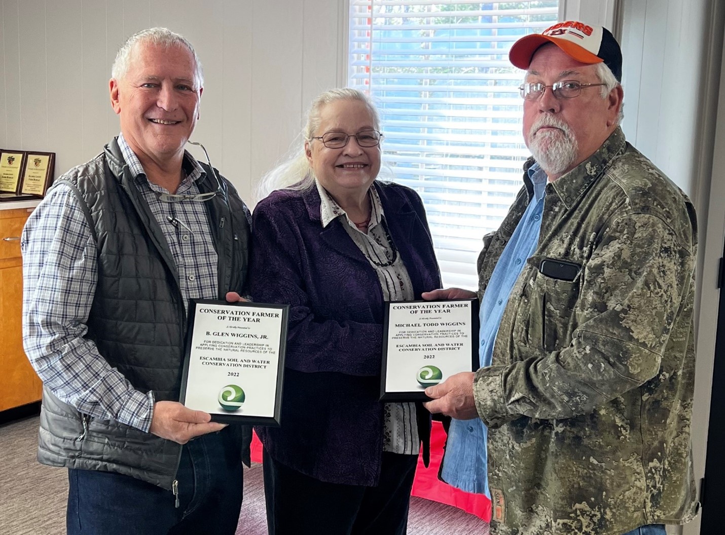 B. Glen Wiggins Jr. (left) and Michael Todd Wiggins (right) were presented the 2022 Conservation Farmers of the Year Award by Chairwoman Betty Wilson (center). Photo courtesy of Debbie Williams.