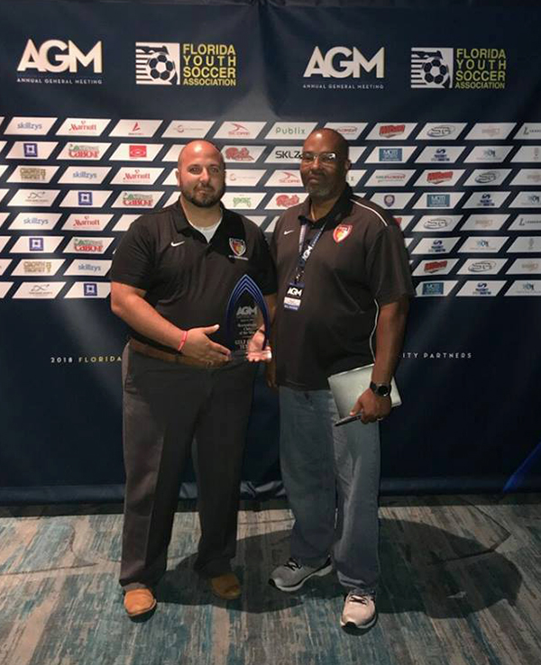 Gulf Coast Texans Recreational Commissioner Alain Espinosa, left, and Gulf Coast Texans President Mark Carr receive the FYSA  Recreational Club of the Year award in Orlando, Florida.