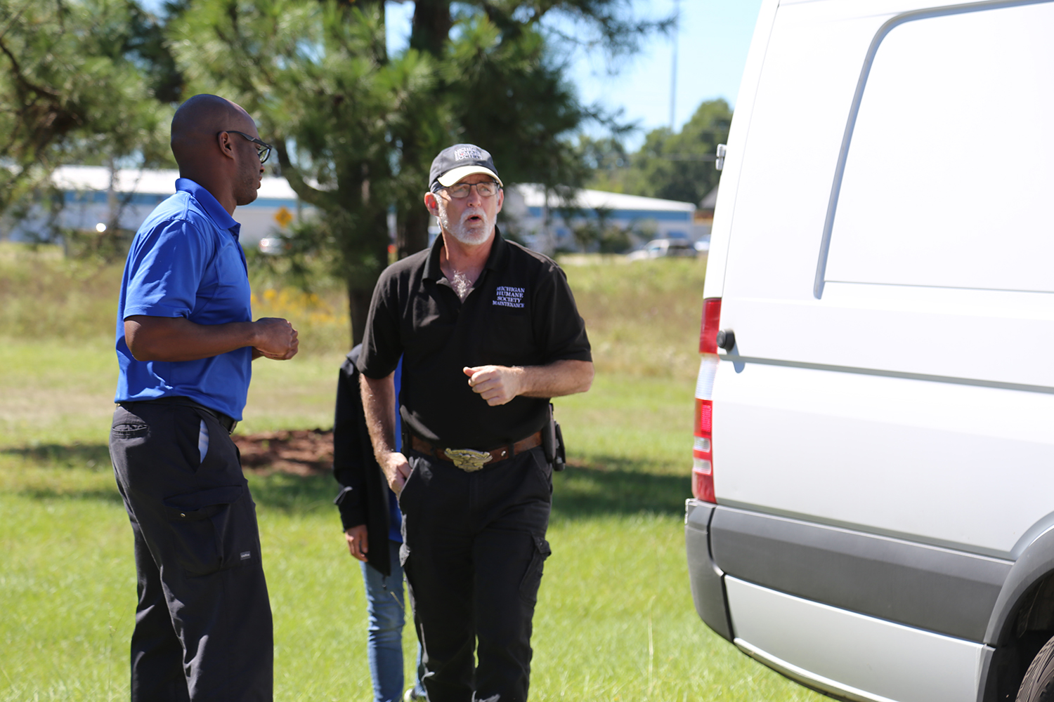 Animal Shelter Staff Talks With Transport Staff Before Loading Dogs for Transfer