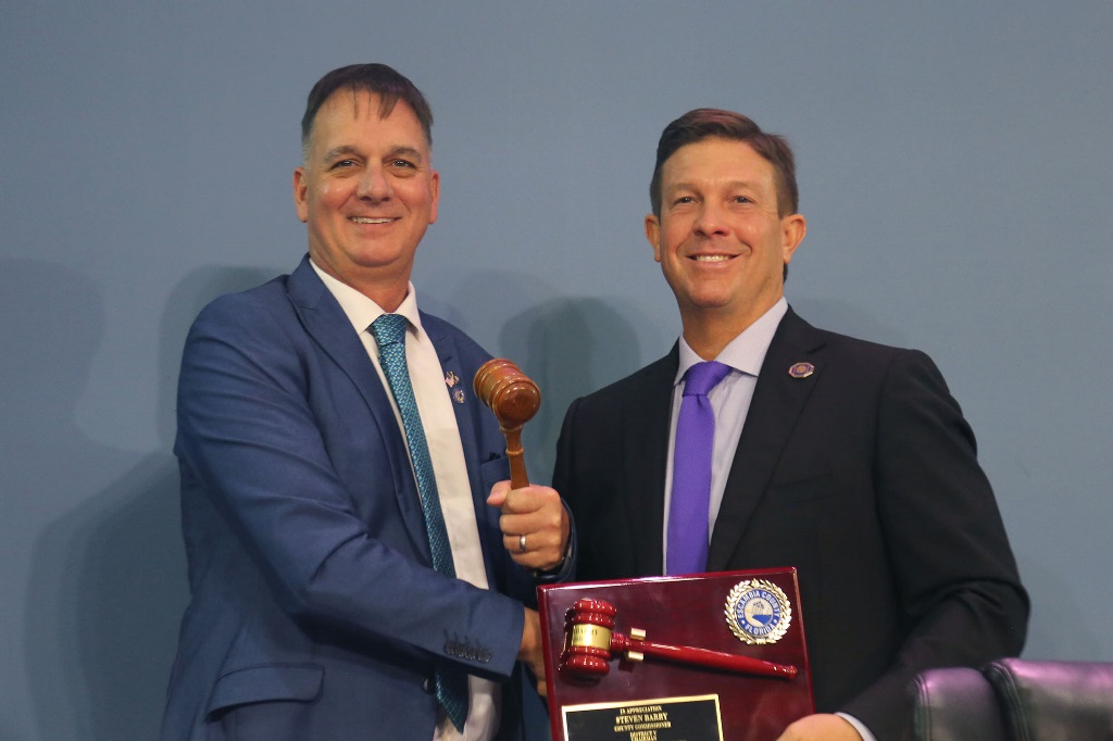 Commissioner Kohler accepts the gavel from Commissioner Barry