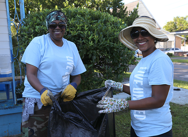 Escambia County Public Safety staff do yardwork at the home of a Council on Aging client as part of the 2018 United Way Day of Caring. 
