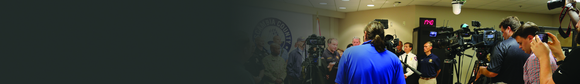 Media outlets hold cameras at a press conference during Hurricane Michael